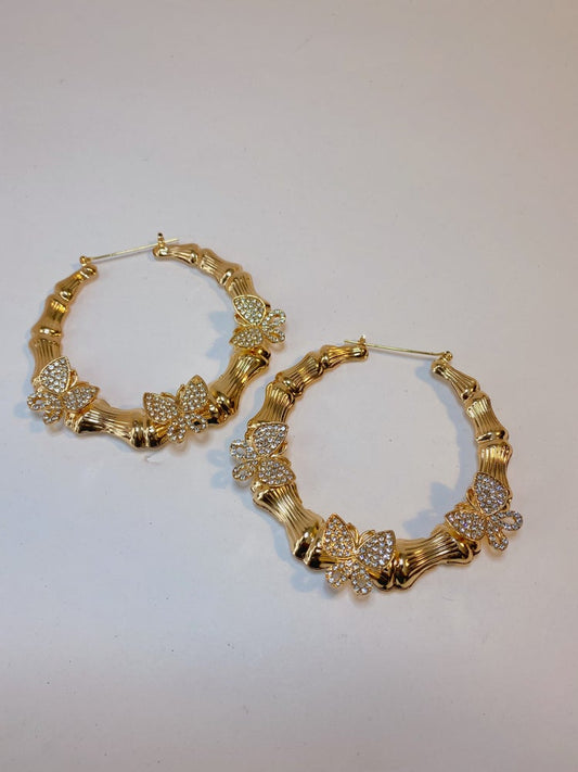 gold bamboo hoop earrings with three gold rhinestone butterfly pendants on each earring